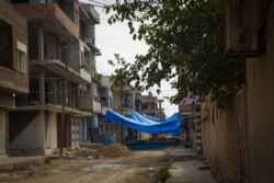 Many neighborhoods have covered their streets with tarps so they go unseen by the drones that have been flying over the city at night, in Darbasiyah, Syria, Oct. 22, 2019. (VOA/Yan Boechat)