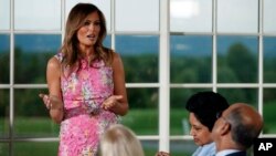 First lady Melania Trump speaks during a dinner meeting with President Donald Trump and business leader in Bedminster, N.J.