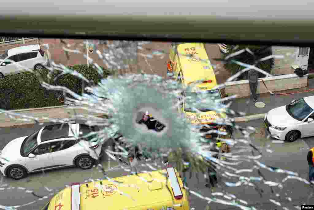 Haifa mayor Yona Yahav in seen through broken glass at a damaged site following a rocket attack from Lebanon towards Israel, in Haifa, Israel.