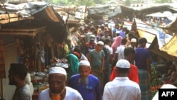 Rohingya refugees walk in market area inside a refugee camp in Ukhia on April 6, 2021 during the second day of weeklong government-imposed lockdown amid an increase of COVID-19 coronavirus cases. (Photo by Miraj KATEB / AFP)