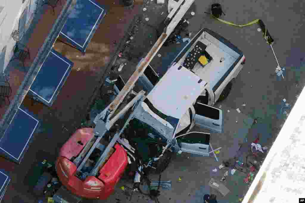 A black flag with white lettering lies on the ground rolled up behind a pickup truck that a man drove into a crowd on Bourbon Street in New Orleans, killing and injuring a number of people, early Wednesday morning, Jan. 1, 2025.