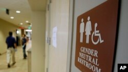 FILE - A sign marks the entrance to a gender-neutral restroom at the University of Vermont in Burlington, Vermont.