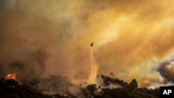 资料照片：直升机在洛杉矶太平洋帕利塞兹社区向正在蔓延的大火喷水。
