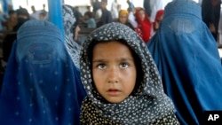 Afghan refugees wait for their documents to go back to Afghanistan at the UNHCR's Repatriation Center in Peshawar, Pakistan, June 23, 2016. 