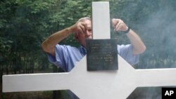 FILE - An Australian veteran adjusts the plague of the cross during a ceremony to mark 40th anniversary of the battle of Long Tan in southern Ba Ria Vung Tau province, Vietnam, Aug. 18, 2006.