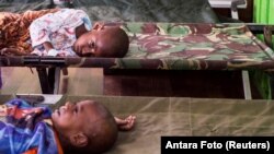 FILE - Two sick children wait for treatment after being admited to a hospital in Agats, Asmat District, after the government dispatched military and medical personnel to the remote region of Papua to combat malnutrition and measles, Indonesia, Jan. 22, 2018. (Antara Foto/M Agung Rajasa/ via REUTERS)