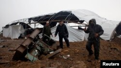 Members of the Palestinian security forces loyal to Hamas inspect the damage after Israeli air strikes on smuggling tunnels in Rafah in the southern Gaza Strip, March 13, 2014. 