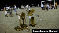Para pengunjung merayakan malam Tahun Baru di tengah wabah virus corona (COVID-19) di Pantai Copacabana, di Rio de Janeiro, Brazil, 1 Januari 2021. (Foto: Lucas Landau/Reuters)