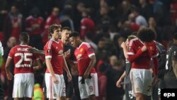 Marouane Fellaini de Manchester United, à droite, Anthony Martial, au centre-droite, Antonio Valencia, à gauche, et Matteo Darmian, au centre-gauche, se parlent à la fin de la du match de football de la ligue d’Europe entre Manchester United et Liverpool,