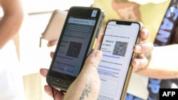 지난 22일 프랑스 암네블르 동물원 입구에서 직원이 방문객의 스마트폰에 담긴 디지털 코로나 백신 증명서를 확인하고 있다. 