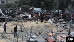 Palestinians look at the debris of tents and make shift homes, following an Israeli military strike on the al-Mawasi camp for internally displaced people (IDP), near the city of Khan Yunis, southern Gaza Strip on July 13, 2024, in which 71 people were kil