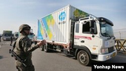 28일 한국 경기도 파주시 통일대교에서 에이스경암의 대북지원 차량이 임진강을 건너고 있다. 이날 에이스경암은 복합비료, 온실 건설자재, 영농기자재 등 농업협력물자 컨테이너 22대 분량을 황해북도 사리원시에 전달할 예정이다. 민간단체 대북 비료지원은 지난 2010년 5·24 제재 조치 이후 이번이 5년 만에 처음이다.