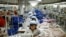 FILE - North Korean workers assemble jackets at a factory of a South Korean-owned company at the jointly run Kaesong Industrial Complex in Kaesong, North Korea, Dec. 19, 2013.