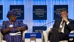 Bill Gates, right, and Nigerian Finance Minister Ngozi Okonjo-Iweala attend a panel session at the World Economic Forum in Davos, January 26, 2012.