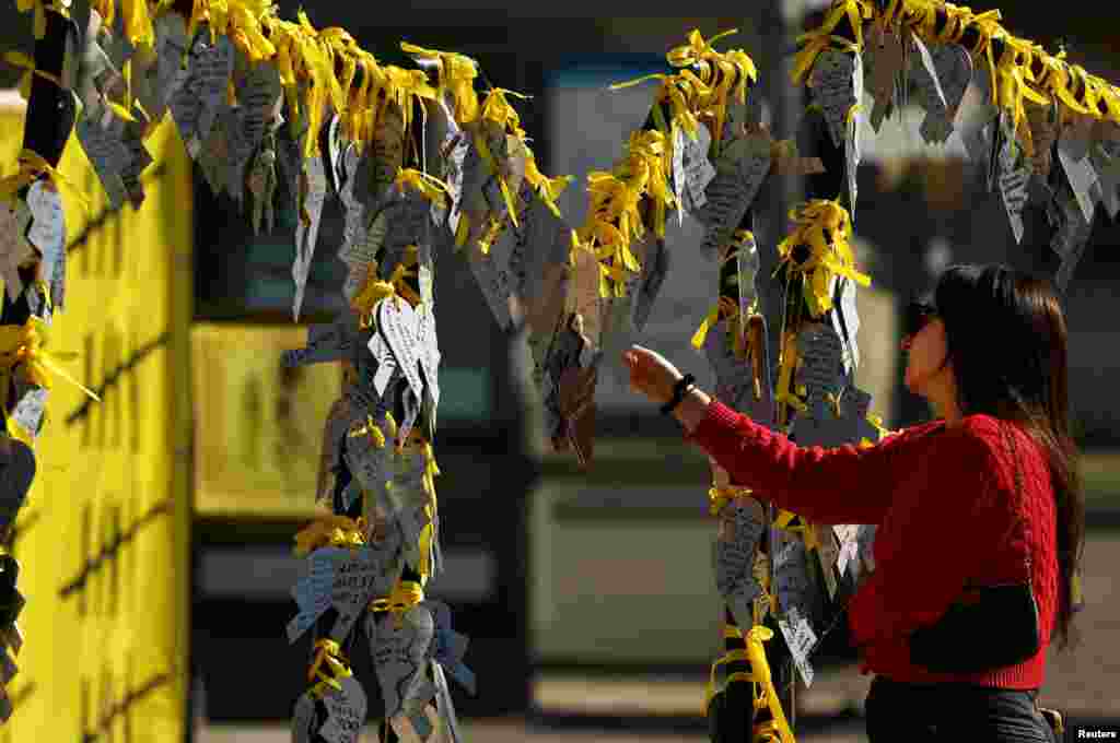 A woman reads messages written on broken heart cutouts for the hostages kidnapped during the deadly October 7, 2023 attack by Hamas, in Tel Aviv, Israel.