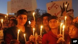 Warga di Ahmadabad, India, menyalakan lilin dalam aksi protes mengecam pemerkosaan beramai-ramai atas seorang perempuan di New Delhi. (AP/Ajit Solanki)