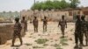 FILE - Soldiers walk among the ruins of the Government Secondary School in Chibok, Nigeria, March 25, 2016.