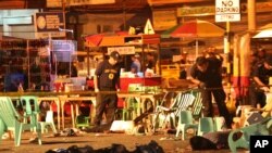 Petugas kepolisisn memeriksa korban yang tewas pasca ledakan di sebuah pasar di selatan kota Davao, Filipina, 2 September 2016 (AP Photo/Manman Dejeto).