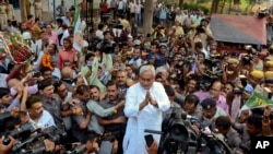 Gubernur Bihar Nitish Kumar, tengah, dikelilingi oleoh media ketika ia menyapa para pendukungnya setelah menang dalam pemilu parlemen negara bagian Bihar di Patna, India, Minggu, 8 November 2015. Aliansi yang dipimpin oleh Kumar mengalahkan partai nasionalis Hindu Perdana Menteri India Narendra Modi, dalam pemilu yang menentukan di salah satu negara bagian terpadat India. (AP Photo/Aftab Alam Siddiqui)