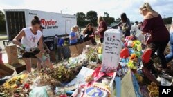 Para relawan, siswa dan orang tua siswa menyortir barang-barang yang diletakkan di lokasi perkabungan untuk 17 siswa dan tenaga akademik yang tewas dalam penembakan di SMU Marjory Stoneman Douglas di Parkland, Florida, 28 Maret 2018.