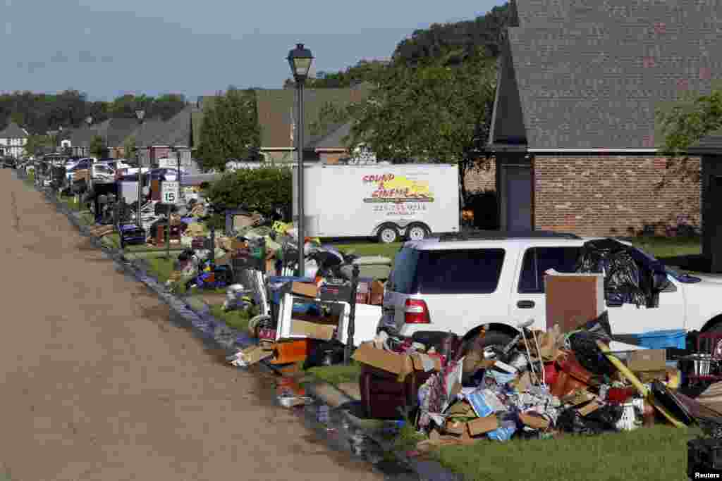 Piles of debris are seen in front of flood-damaged homes in St. Amant, Louisiana, Aug. 21, 2016.