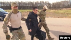 L'ancien Marine Trevor Reed est escorté jusqu'à un avion par des militaires russes dans le cadre d'un échange de prisonniers entre les États-Unis. et la Russie, à Moscou, en Russie, sur cette image tirée d'une vidéo publiée le 27 avril 2022.