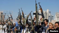 Armed Houthi followers raise their rifles at a gathering showing support for their movement in Sanaa, Yemen. 