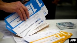 Votes are counted during caucusing in the 66th precinct at Abraham Lincoln High School in Des Moines, Iowa, on February 3, 2020. (Photo by JIM WATSON / AFP)