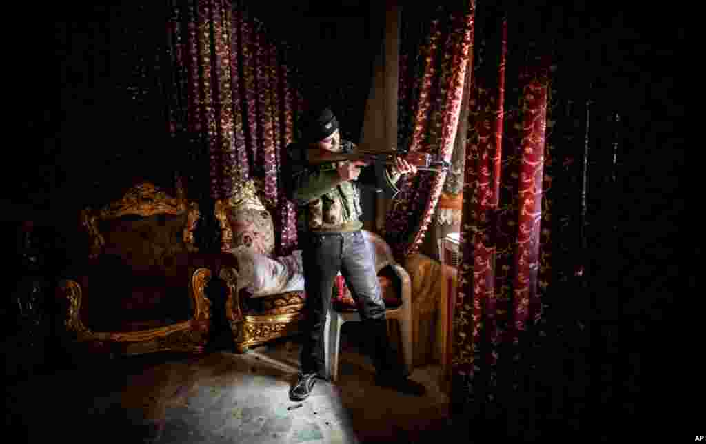 A Free Syrian Army fighter aims his weapon in the Saif al-Dawlah neighborhood of Aleppo, Syria, January 13, 2013.
