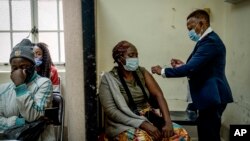 A woman is vaccinated against COVID-19 at the Hillbrow Clinic in Johannesburg, South Africa, Dec. 6, 2021. (AP Photo/ Shiraaz Mohamed)