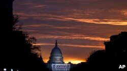FILE - The U.S. Capitol Building is illuminated during sunrise in Washington.