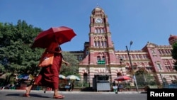 FILE - A Buddhist monk walks near the High Court in Rangoon, Nov. 26, 2011. 
