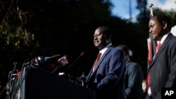Kenya's opposition leader Raila Odinga, center, accompanied by party official Kalonzo Musyoka, right, announces they will challenge the results of last week's presidential election in the Supreme Court and wage a campaign of "civil disobedience," at a press conference in Nairobi, Kenya, Aug. 16, 2017. 