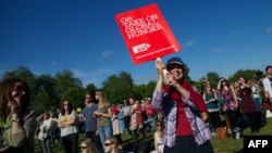 A demonstrator holds a placard calling on the G8 to take on global hunger, at a rally in Hyde Park, central London, June 8, 2013. 
