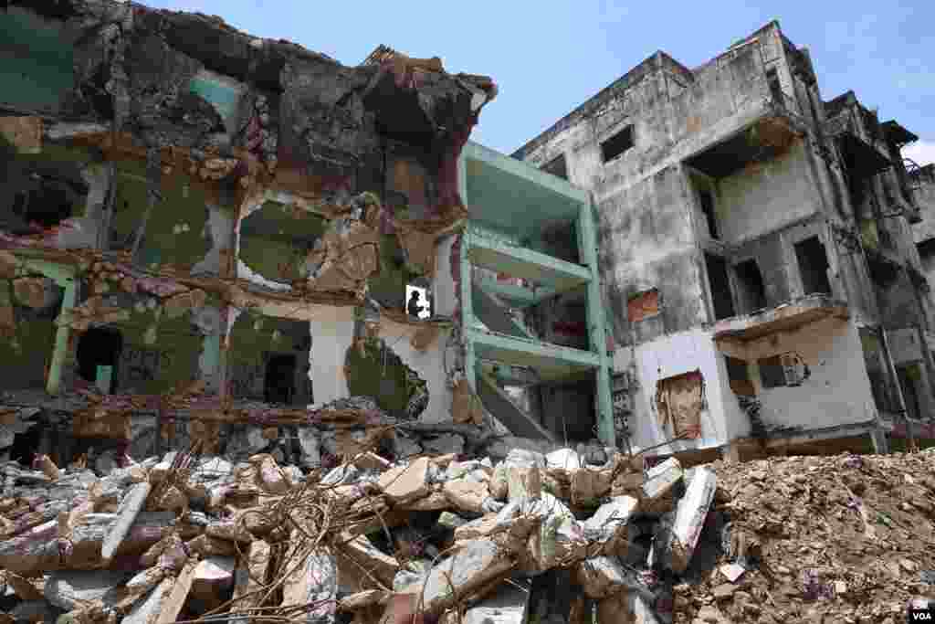 ទិដ្ឋភាព​នៃ​ការ​វាយកម្ទេច​អគារប៊ូឌីញ​ "អគារ ស​" ក្នុង​រាជធានី​ភ្នំពេញ​ នាថ្ងៃទី៣​ ខែសីហា​ ឆ្នាំ២០១៧។ ​អគារ​ប៊ូឌីញ​ កសាង​ឡើង​ក្នុង​អំឡុង​ឆ្នាំ១៩៦០​ ហើយ​អគារ​នេះ​ចាប់ផ្តើម​វាយកម្ទេច​នា​ខែ​ កក្កដា​ ឆ្នាំ​២០១៧។ ​(រ៉ាវី សុភារ័ត្ន/VOA)