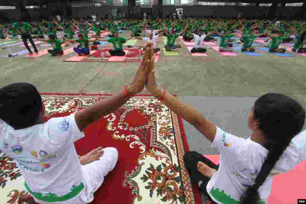 គ្រូបង្ហាត់យោគៈពន្យល់អ្នកចូលរួមប្រមាណជាង១០០០នាក់ប្រមូលផ្ដុំគ្នានៅពហុកីឡាដ្ឋានអូឡាំពិកនៃ រាជធានីភ្នំពេញ នៅថ្ងៃអាទិត្យ ទី១៩ ខែមិថុនា ឆ្នាំ២០១៦ ដើម្បីប្រារព្ធទិវាយោគៈអន្តរជាតិក្នុងគោលបំណងរក្សាសុខភាពឲ្យបានប្រសើរជាងមុន។​មនុស្សទូទាំងពិភពលោកនាំគ្នាហាត់យោគៈដើម្បីរក្សាសុខភាពឲ្យបានល្អ និងដើម្បីឲ្យតម្លៃប្រពៃណីឥណ្ឌាបុរាណ។(ឡេង ឡែន/VOA)&nbsp;