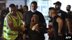 Palestinians assist a wounded woman amid clashes with Israeli security forces in Jerusalem's Old City, May 8, 2021.