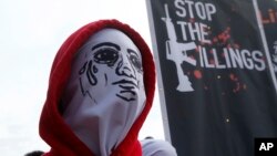 Seorang demonstran Filipina yang mengenakan topeng, mengecam kebijakan perang melawan narkoba pemerintahan Presiden Rodrigo Duterte yang telah banyak memakan korban jiwa - dalam aksi protes yang bersamaan waktunya dengan pidato kenegaraan Duterte di depan parlemen Filipina, Senin (23/7). 