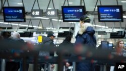 A man wears a protective mask as he waits to check into a flight to the United States in the main terminal of Brussels International Airport in Brussels, March 13, 2020.