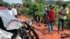 In this photo provided by Cambodia National Police, onlookers stand around the mangled wreckage of Cambodia's Prince Norodom Ranariddh's car after a collision with another vehicle outside Sihanoukville, Cambodia, Sunday, June 17, 2018. 