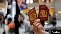 Seorang pengunjuk rasa menunjukkan paspor British National Overseas (BNO) dalam demo menentang undang-undang keamanan nasional baru di Hong Kong, 1 Juni 2020.