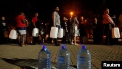FILE - People queue to collect water from a spring in the Newlands suburb as fears over the city's water crisis grow in Cape Town, South Africa, Jan. 25, 2018.