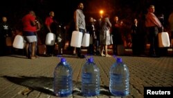 People queue to collect water from a spring in the Newlands suburb as fears over the city's water crisis grow in Cape Town, South Africa, Jan. 25, 2018.