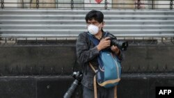 FILE - AFP photographer Alfredo Estrella wears a face mask as he works during the coronavirus pandemic, in Mexico City, Mexico, April 8, 2020. 