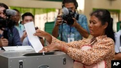 ស្ត្រី​ម្នាក់​ដាក់​សន្លឹកឆ្នោត​ក្នុង​ហឹបឆ្នោត​នៅ​ការិយាល័យ​បោះឆ្នោត​ក្រុងតាខ្មៅ​ខេត្ត​កណ្តាល ប្រទេស​កម្ពុជាកាលពីថ្ងៃទី​២៩ កក្កដា ឆ្នាំ២០១៨។