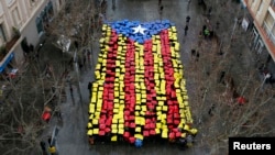 People hold placards to form a giant Catalan flag in front of Sant Feliu townhall, near Barcelona, Feb. 16, 2014. 