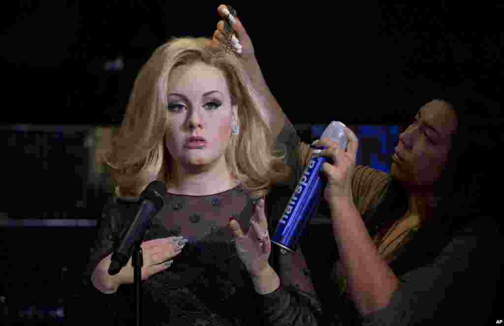 Perias Gemma Sim (kanan) merapikan rambut patung lilin penyanyi Inggris Adele, di museum lilin Madame Tussaud, London.