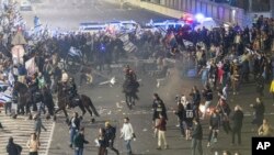 이스라엘 경찰이 27일 텔아비브 시내 도로를 점거한 사법개혁 반대 시위대를 해산하고 있다.