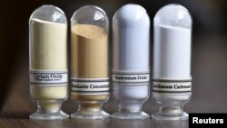 FILE - Samples of rare earth minerals from left, Cerium oxide, Bastnasite, Neodymium oxide and Lanthanum carbonate are on display during a tour of Molycorp's Mountain Pass Rare Earth facility in Mountain Pass, California, June 29, 2015. 