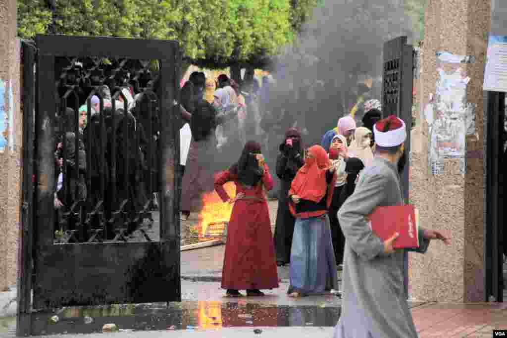 Female Islamist students burn debris during a protest at Al-Azhar University in Cairo, Dec. 11, 2013. (Hamada Elrasam for VOA)